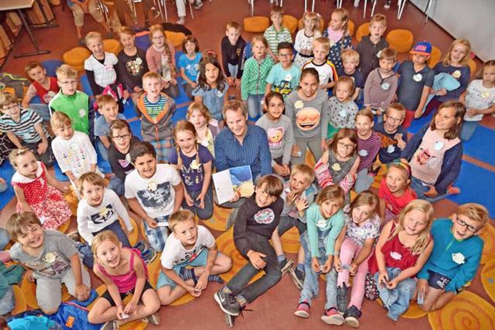 Kinderbuchautor und Illustrator Jens Rasmus auf „Augenhöhe“ mit seinen Zuhörern, den Erst- und Zweitklässlern der Preetzer Friedrich-Ebert Grundschule.