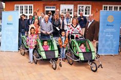Offizielle Übergabe mit fünf symbolischen Fahrradanhängern, Flüchtlingen und Helfern: Bürgermeisterin Hatice Kara (vorne von links), Udo Meier und Sabine Lehners von der „Helferbörse“ bedanken sich bei Dr. Christoph Lehners, Präsident des Rotary Club Lübecker Bucht Timmendorfer Strand, für die Spende. (Foto: René Kleinschmidt)