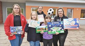Irina Lüth (Leiterin „Zauberhut“, li.) freut sich mit Helene und Maria über das Spielzeug, das Silke Mildner (re.) und Susanne Handt vom reporter übergaben.