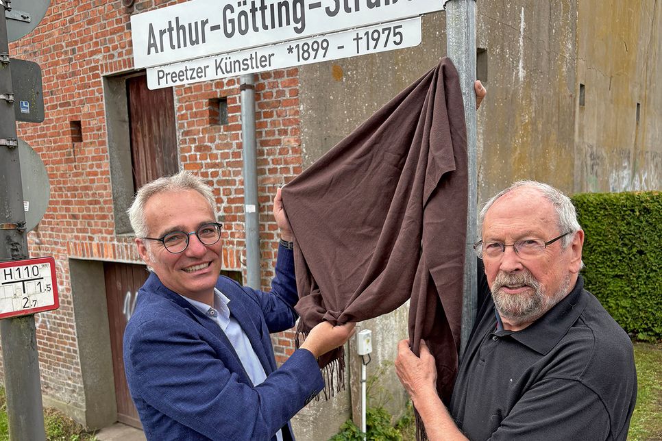 Bürgermeister Tim Brockmann (li.) und Stadtpräsident Hans-Jürgen Gärtner enthüllen am 7. Juli das neue Straßenschild.