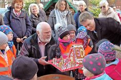 Zur Eröffnung des 30. Zwergenwaldes überrreichten die Kinder aus den städtischen Kindergarten „Wirbelwind“ gemeinsam mit Bad Schwartaus Bürgermeister Dr. Uwe Brinkmann (r.) ein Lebkuchenhaus an „Zwergenvater“ Rolf Kirsten.