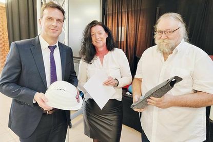 Zur Begrüßung wurde dem neuen Schulleiter Wolfram Henkies (links) von Bürgermeisterin Bettina Schäfer und Sozialausschuss-Vorsitzenden Jürgen Brede ein Bauhelm, eine Flasche Wein aus der Partnerstadt Lagoa und ein Accessoire für seinen Schreibtisch überreicht.