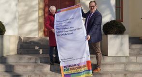 Heinke Hafemann, Gruppensprecherin von Amnesty International Neustadt und Bürgermeister Mirko Spieckermann präsentieren den neuen Banner.