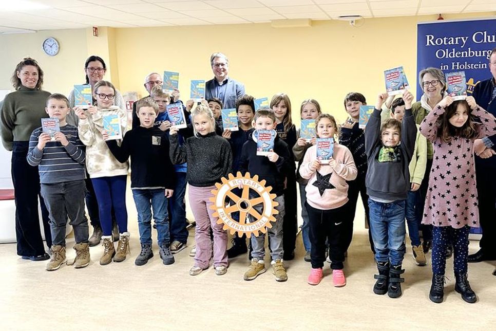 Die Kinder der 2. Klassen freuen sich über die geschenkten Bücher. v.l.: Rektorin Angela Haar, Grundschulkoordinatorin Stefanie Clasen, Rotarier Klaus Basting-Neumann und Jens Griebel, Projektleiterin Susanne Knees, Präsident Uwe Lankau, Rotarier Andreas Mylius und Schülerinnen und Schüler der 2. Klassen.