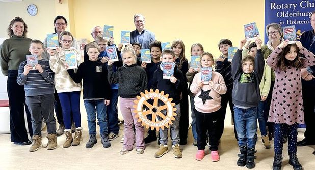 Die Kinder der 2. Klassen freuen sich über die geschenkten Bücher. v.l.: Rektorin Angela Haar, Grundschulkoordinatorin Stefanie Clasen, Rotarier Klaus Basting-Neumann und Jens Griebel, Projektleiterin Susanne Knees, Präsident Uwe Lankau, Rotarier Andreas Mylius und Schülerinnen und Schüler der 2. Klassen.