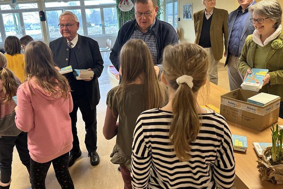 Die Schülerinnen und Schüler der 4. Klassen bekommen Bücher geschenkt. v.L.: Rotarier Klaus Basting-Neumann, Präsident Uwe Lankau, Andreas Mylius, Jens Griebel, Projektleiterin Susanne Knees mit Schülerinnen und Schülern der 4. Klassen.