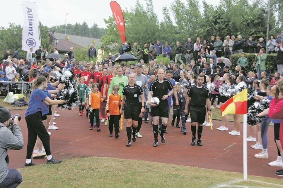 Gute Stimmung zum Spielstart: Die Schieris führen die Fußballlegenden auf den Platz.