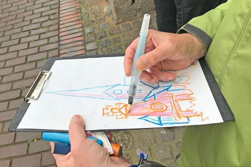 So einfach wie originell: Mit dem Wassertankpinsel werden die Linien der Wachsstifte verwischt. Flächen und Räumlichkeiten entstehen.