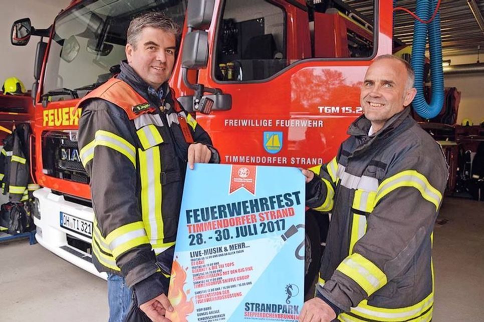 Wehrführer Björn Jessen (rechts) und sein Stellvertreter Dirk Scharbau von der Freiwilligen Feuerwehr Timmendorfer Strand freuen sich auf drei Tage Grill- und Sommerfest rund um den Seepferdchenbrunnen. (Foto: René Kleinschmidt)
