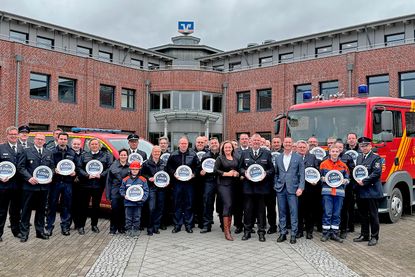 Die Kameradinnen und Kameraden der Freiwilligen Feuerwehr Lensahnerhof hatten mit ihren Fahrzeugen am Vorstandssitz Ost der VR Bank zwischen den Meeren in der Straße zum Windpark 9 in Lensahn einen schönen Rahmen für ein Gruppenfoto geschaffen.