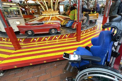 Während das Karussell sich dreht, erinnert der leere Rollstuhl an den Alltag der Kinder, die auf dem Weihnachtsmarkt einige unbeschwerte Momente erleben durften.