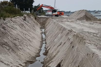 Mindestens drei Meter tief wird der Graben, in dem die Steinvorlage die Mauer als Widerlager zukünftig schützen soll.