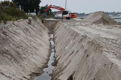 Mindestens drei Meter tief wird der Graben, in dem die Steinvorlage die Mauer als Widerlager zukünftig schützen soll.
