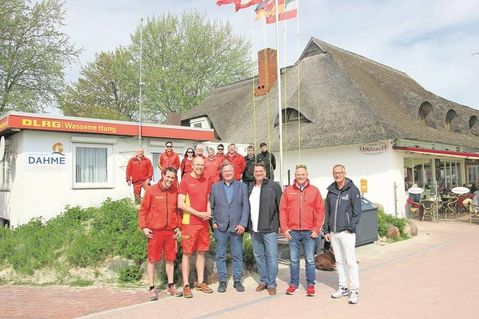 Freuen sich auf die neue Saison (vorne v. lks.): Sebastian Görgen, Jochen Möller, Bürgermeister Dieter Knoll, Thomas Warkentin, Klaus Holger Hecken und Tourismusleiter Thorsten Dücker mit einem Teil des DLRG-Teams vor der Rettungswache an der Strandpromenade von Dahme.