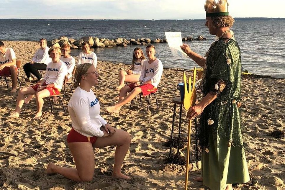 Neptun bei der Ausübung seiner Amtshandlung mit Toilettenbürste und frischem Ostseewasser.