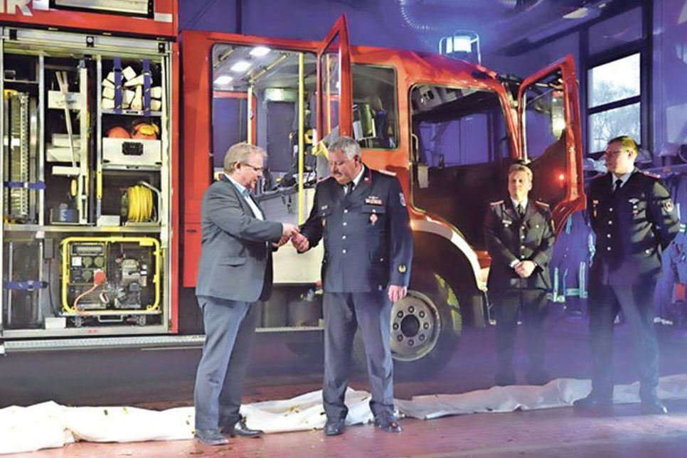 Bürgermeister Lars Winter übergibt den Schlüssel für das neue 300000 Euro teure Löschfahrzeug an Ex-Wehrführer Horst Stüwe, der diese wiederum dem Gruppenführer Alexander Gripp aushändigt.