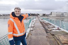 Techniker Dirk Dibbern vom Bauamt der Gemeinde Scharbeutz zeigt auf die im Bau befindliche Seebrücke, auf der jetzt das Belagsholz verlegt und montiert wird.