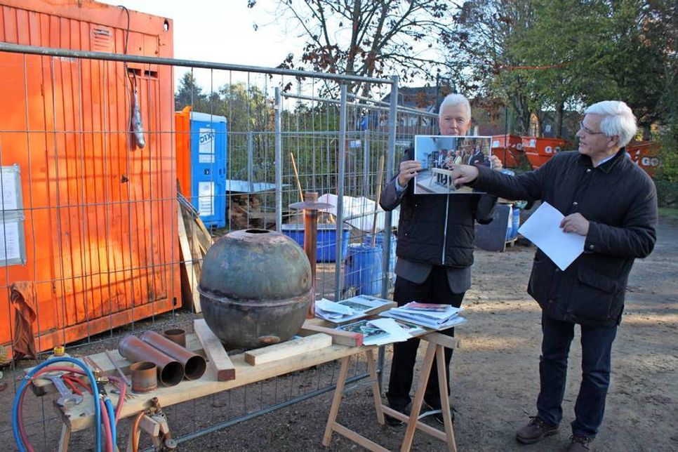 Torsten Ewers (lks.) und Vorsitzender Kirchenvorstand Fritz Bormann bei der Erläuterung der Schriften, mit der die Turmkugel befüllt wurde.