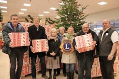 Pastor Torsten Marienhagen, Pastor Jens Rathjen, Monika Rieth und Marion Esser vom Kinderschutzbund, Lions-Organisatorin Juliana Stolz, Pastor Andreas Hasse und Marktleiter Jörg Flad (v. lks.) mit den Paketen, die mit weihnachtlichen Leckereien versehen wurden.