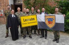 Pastorin Sarah Lotzkat (vorne lks.), 3. stellvertretender Bürgermeister Mathias Schmidt (2. v. re.) und Major David Cacic (re.) mit den verabschiedeten Soldaten aus Eutin.