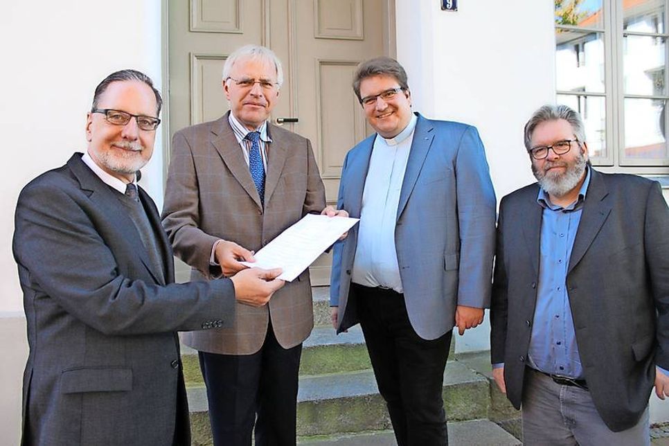 1. Vorsitzender Stefan Kramer nahm den Anerkennungsbescheid von Landrat Reinhard Sager im Beisein der Initiatoren Propst Dirk Süssenbach und dem 2. Vorsitzenden Heiner Backer entgegen (v. lks.).