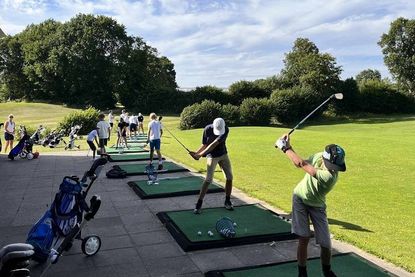 Gemeinsames Aufwärmen unter der Leitung als Golfer auf der Drivingrange.