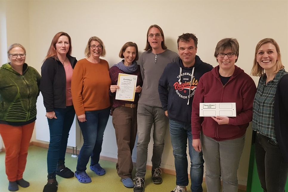 Der Leiter der Einrichtung „Kita „Am Wasserturm“ mit der Außenstelle „Schatzinsel“, Karsten Schau (3. v. re.), freut sich mit seinem Team über die erneute Auszeichnung.