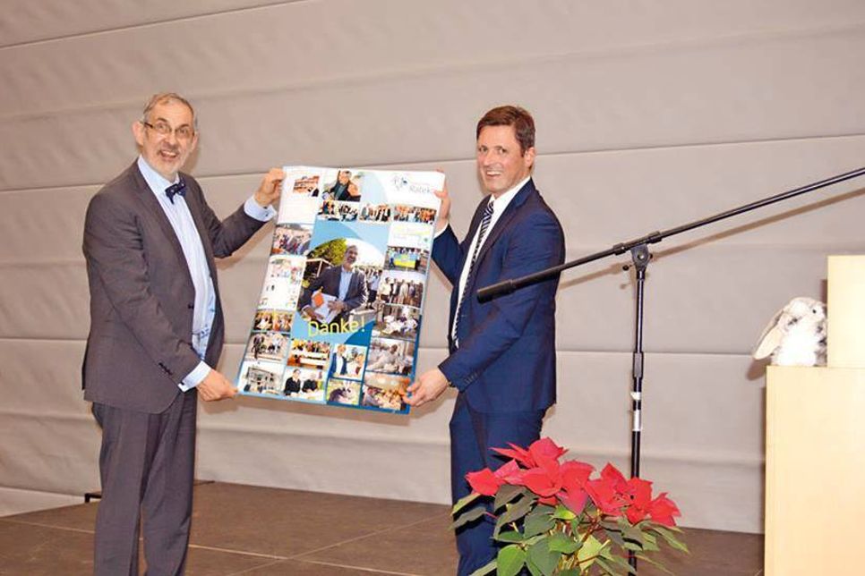 Ratekaus Bürgermeister Thomas Keller übergibt eine Collage an den scheidenden Schulleiter. (Foto: Setje-Eilers)