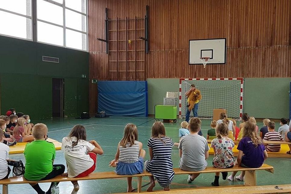 Die Grundschulkinder treffen sich zur Theateraufführung in der Sporthalle.