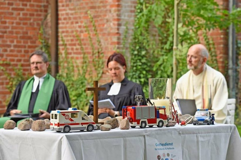 Improvisierter Altar mit den Steinen, im HIntergrund Pastor Hieber, Pastorin Warnemünde und Pastor Noll