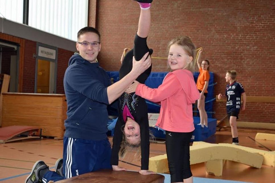 Kolja Harm gibt seinen Töchtern Neila (6) und Malia (5) Hilfestellung beim „Bogengang vorwärts“.