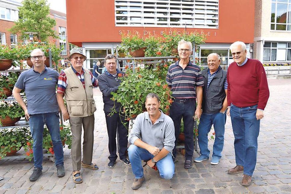 Die fleißigen Helfer des Gemeinnützigen Bürgervereins um Vorstandsmitglied Mathias Fahr (knieend) haben jetzt wieder die beliebten Blumenampeln im Stadtgebiet aufgehängt.