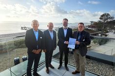 Manfred Wohnrade (Betriebsleiter des Tourismus-Service Grömitz), Matthias Dammer (Bürgervorsteher), Claus Ruhe Madsen (Minister für Wirtschaft, Verkehr, Arbeit, Technologie und Tourismus) und Sebastian Rieke (Bürgermeister; v. lks.) bei der Übergabe.
