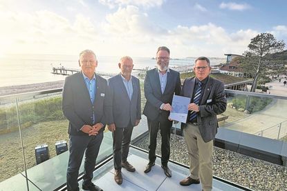 Manfred Wohnrade (Betriebsleiter des Tourismus-Service Grömitz), Matthias Dammer (Bürgervorsteher), Claus Ruhe Madsen (Minister für Wirtschaft, Verkehr, Arbeit, Technologie und Tourismus) und Sebastian Rieke (Bürgermeister; v. lks.) bei der Übergabe.