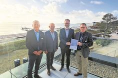 Manfred Wohnrade (Betriebsleiter des Tourismus-Service Grömitz), Matthias Dammer (Bürgervorsteher), Claus Ruhe Madsen (Minister für Wirtschaft, Verkehr, Arbeit, Technologie und Tourismus) und Sebastian Rieke (Bürgermeister; v. lks.) bei der Übergabe.