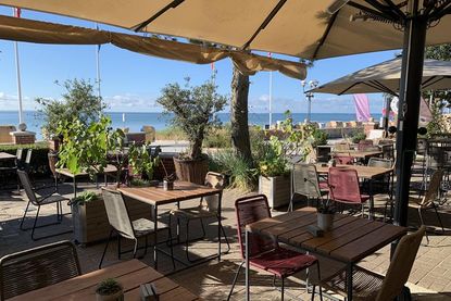 Direkt an der Kurpromenade gelegen, lädt die stilvolle Terrasse mit Olivenbäumen aus Montenegro zum Verweilen ein.