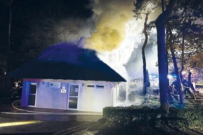 Mit einem angeforderten Bagger musste das brennende Reetdach vom Strandimbiss später entfernt werden.