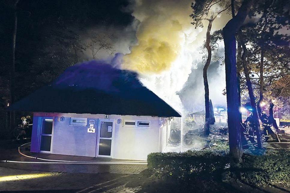 Mit einem angeforderten Bagger musste das brennende Reetdach vom Strandimbiss später entfernt werden.
