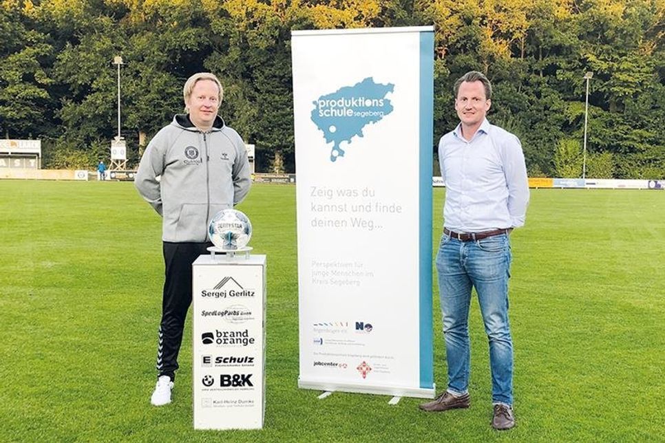 Lennart Landsberg, Geschäftsführer der JobA, übergibt die Fußballsäule an Helge Thomsen zum ersten Heimspiel des TSV Pansdorf in der Oberliga-Saison.