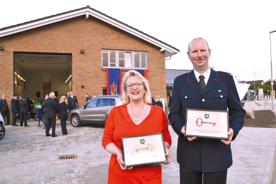 Nach dem Durchschneiden des Bandes durften Dorfvorsteherin Sandra Radünz und Ortswehrführer Thomas Brede die symbolischen Schlüssel für das neue Haus in Empfang nehmen. (Foto: René Kleinschmidt)