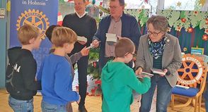 Rotarier schenken Kindern der 2. Klassen Bücher - v.l.: Kinder der 2. Klassen, Rotarier Dieter Fischer, Präsident Uwe Lankau.