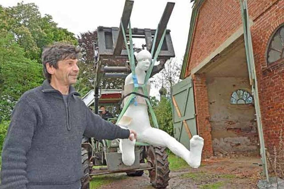 Vorsichtiges Manöver auf unebener Piste: Die gewichtige Skulptur wird mit Fingerspitzengefühl an ihren neuen Standort transportiert.