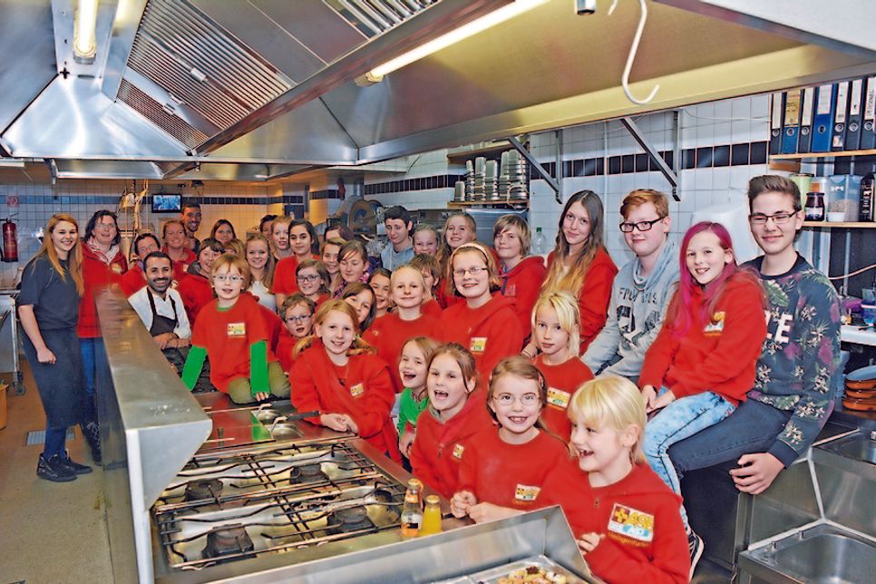 Nach dem gemeinsamen Backen stellten sich die Arbeiter-Samariter-Jugend sowie das "Doppeleichen" Team zu einem Gruppenfoto in der Restaurant-Küche auf.