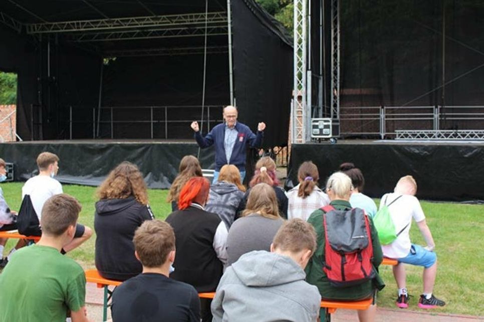 Hans-Wilhelm Hagen (Geschäftsführender Gesellschafter der Stiftung Neue Musik-Impulse GmbH) begrüßt die Schüler*innen im Eutiner Küchengarten