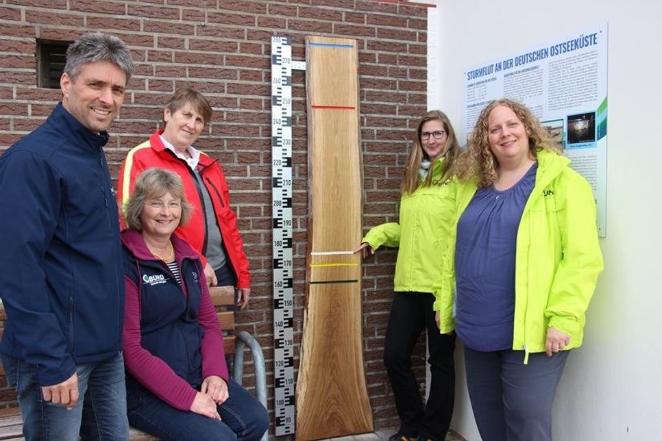 2017 stieg das Wasser bis zur weißen Linie, zeigen Stefanie Sudhaus und Svenja Beilfuß vom BUND (v. re.). Wichtige Partner bei der Umsetzung des Projekts waren Stephan Reil (Tourismus-Service), Martina Stapf (Umwelthaus) und Regina Block (DLRG; v. lks.).