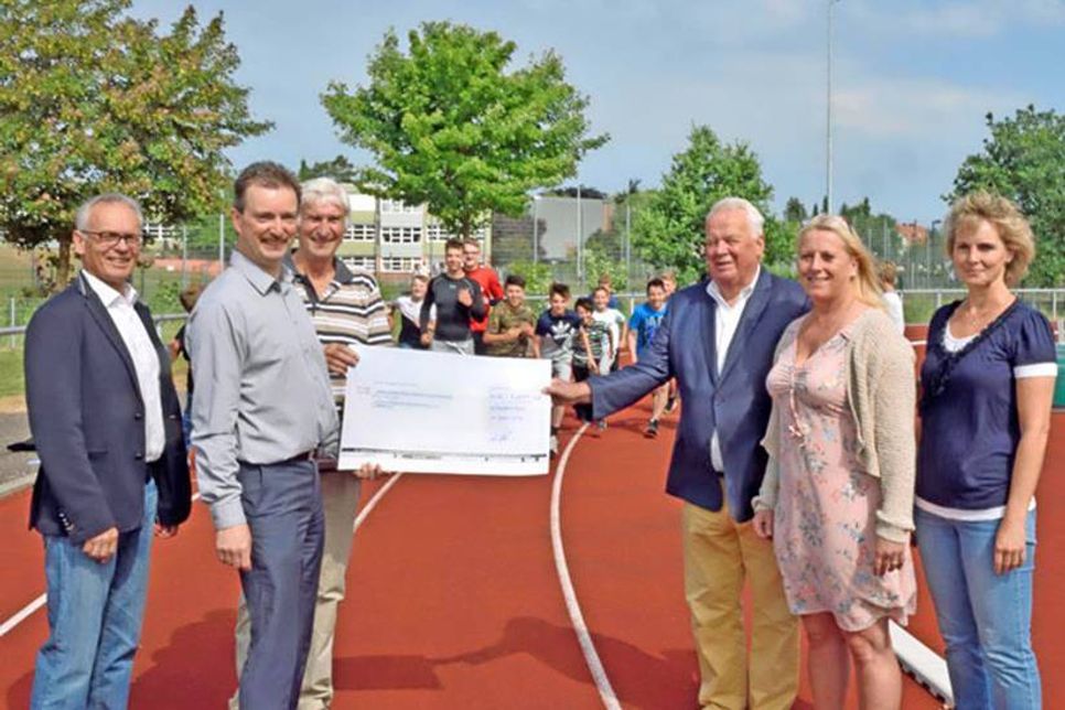 (V. l.) Die Mitglieder des Kinderhilfswerks Michael Koops, Jörn Stoß vom Förderverein der Schule im Augustental, Walter Bischoff, Kinderhilfswerks-Vorsitzender Eckhard Jensen und Grundschullehrerin Caroline Heinrich sowie Schulleiterin Solveig Märzhäuser präsentieren den symbolischen Scheck mit der gesponserten Summe für die erlaufenen Kilometer.