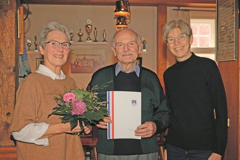 Übungsleiterin Anke Försterling (links) und KSV-Vorsitzende Birgit Kamrath-Meyer nehmen Harald Abratis, den aktuell einzigen Mann in der 100 Jahre alten Johanna-Frick-Riege, bei der Geburtstagsfeier „in ihre Mitte“.