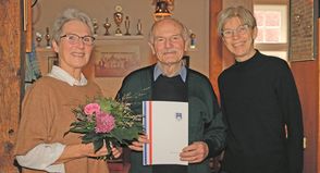 Übungsleiterin Anke Försterling (links) und KSV-Vorsitzende Birgit Kamrath-Meyer nehmen Harald Abratis, den aktuell einzigen Mann in der 100 Jahre alten Johanna-Frick-Riege, bei der Geburtstagsfeier „in ihre Mitte“.