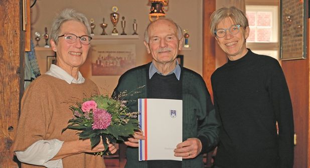 Übungsleiterin Anke Försterling (links) und KSV-Vorsitzende Birgit Kamrath-Meyer nehmen Harald Abratis, den aktuell einzigen Mann in der 100 Jahre alten Johanna-Frick-Riege, bei der Geburtstagsfeier „in ihre Mitte“.