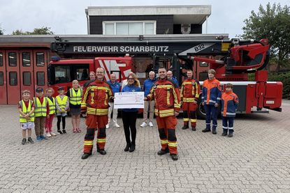 Carolin Dreismann, Präsidentin des Lions Club Lübecker Bucht, überreicht einen Scheck in Höhe von 4.000 Euro an Bo Anderson und David Siegmund für die Kinder- und Jugendfeuerwehr Scharbeutz.